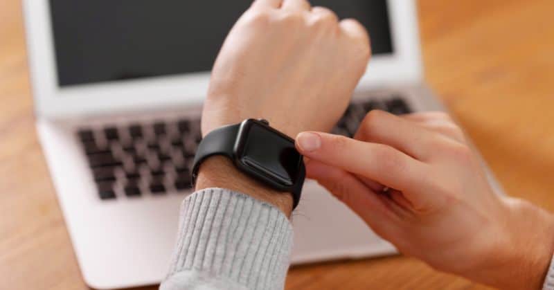 ידיו של אדם נוגעות ב-Apple Watch